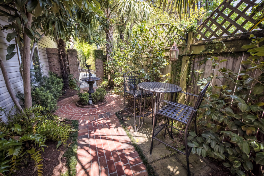 lush outdoor garden walkway with fountains and chairs Wilmington Vacation Homes